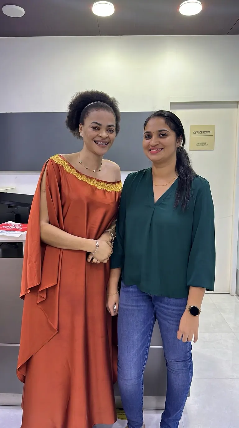 A smiling orthodontic patient with Dr. Deepthi Chandran at the clinic reception